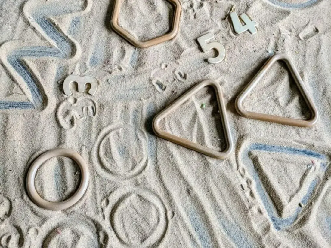 Therapiematerial in der Ergotherapie: Formen und Zahlen im Sand nachgezogen